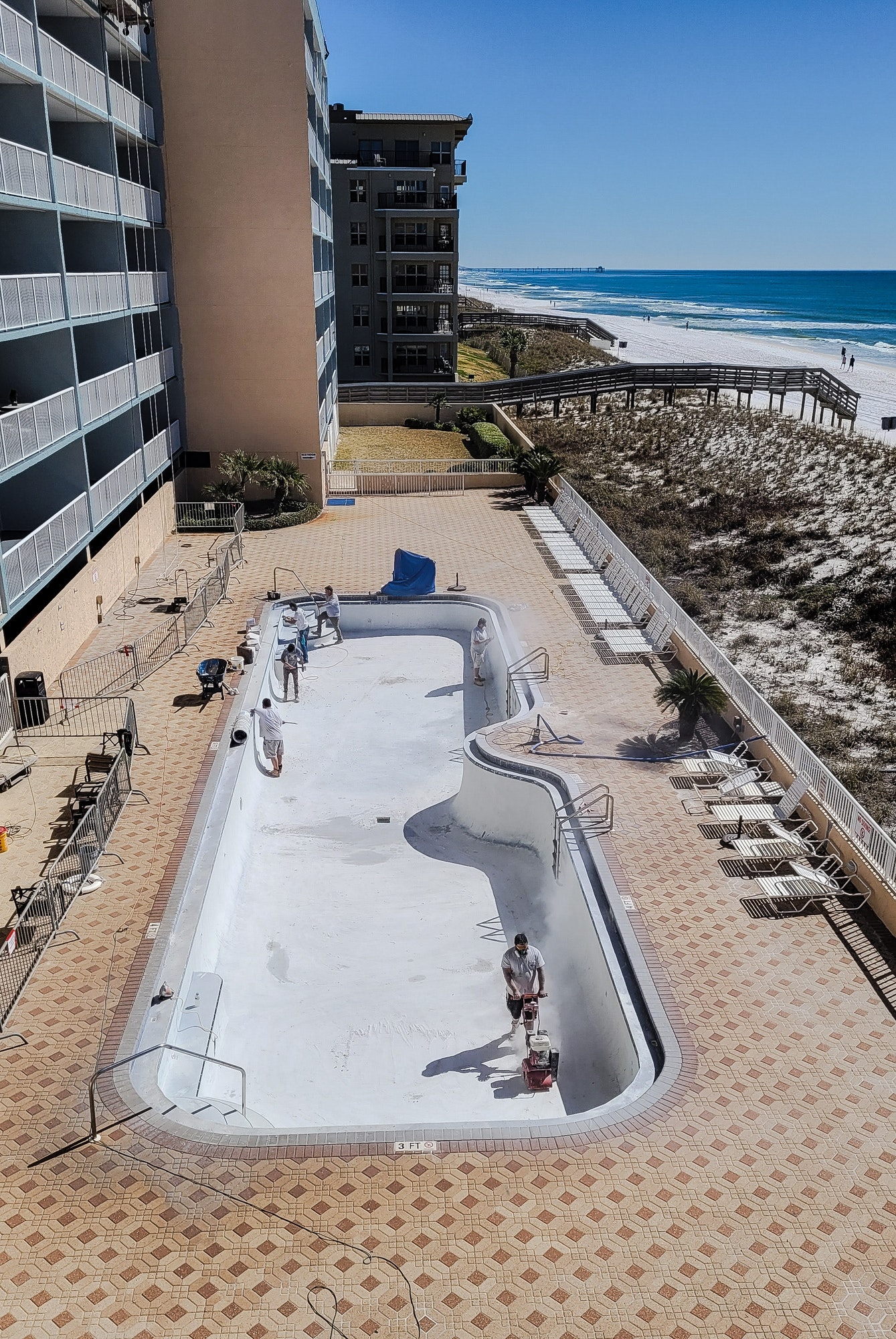 A beach pool is being resurfaced for tourists renting to enjoy pool on vacation.